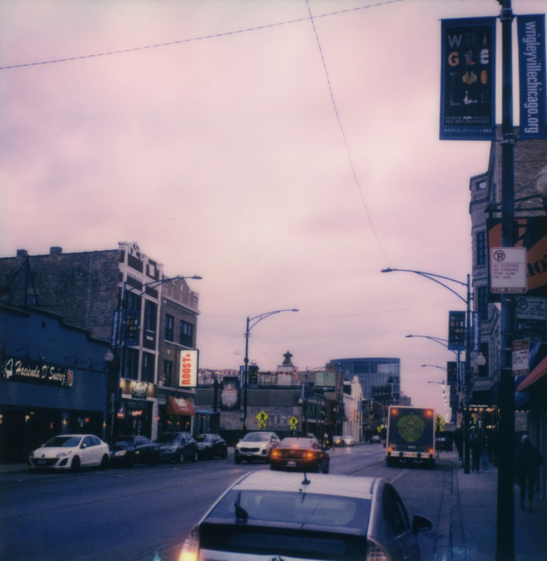 A photograph looking North on Clark Street in Chicago, we can see a cloudy sky and several cars